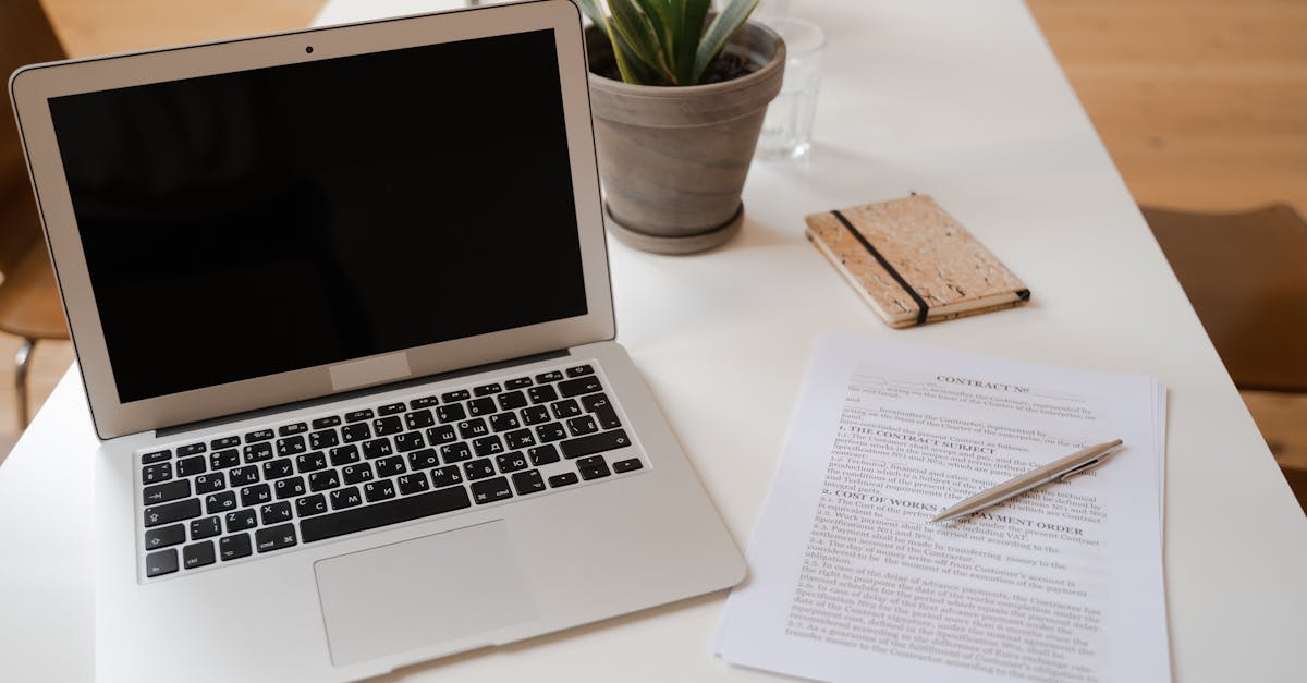 A laptop, printed PDF forms, and a coffee cup on a clean wooden desk, ready for repeat form filling.