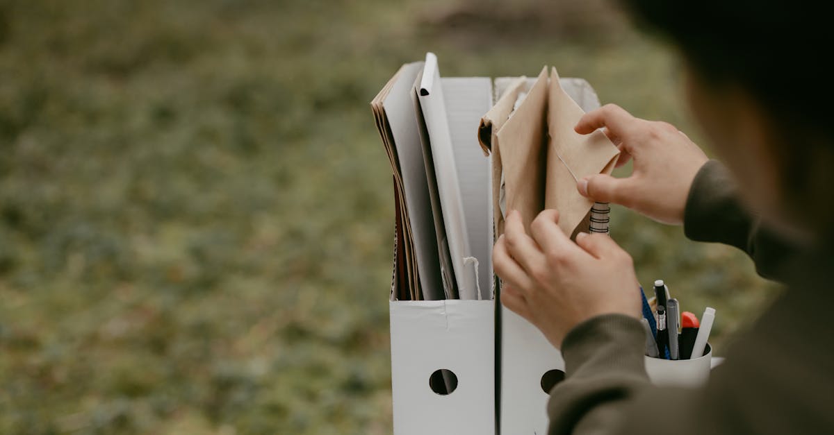 Hands organizing immigration case files in folders, sorting documents for a family packet.